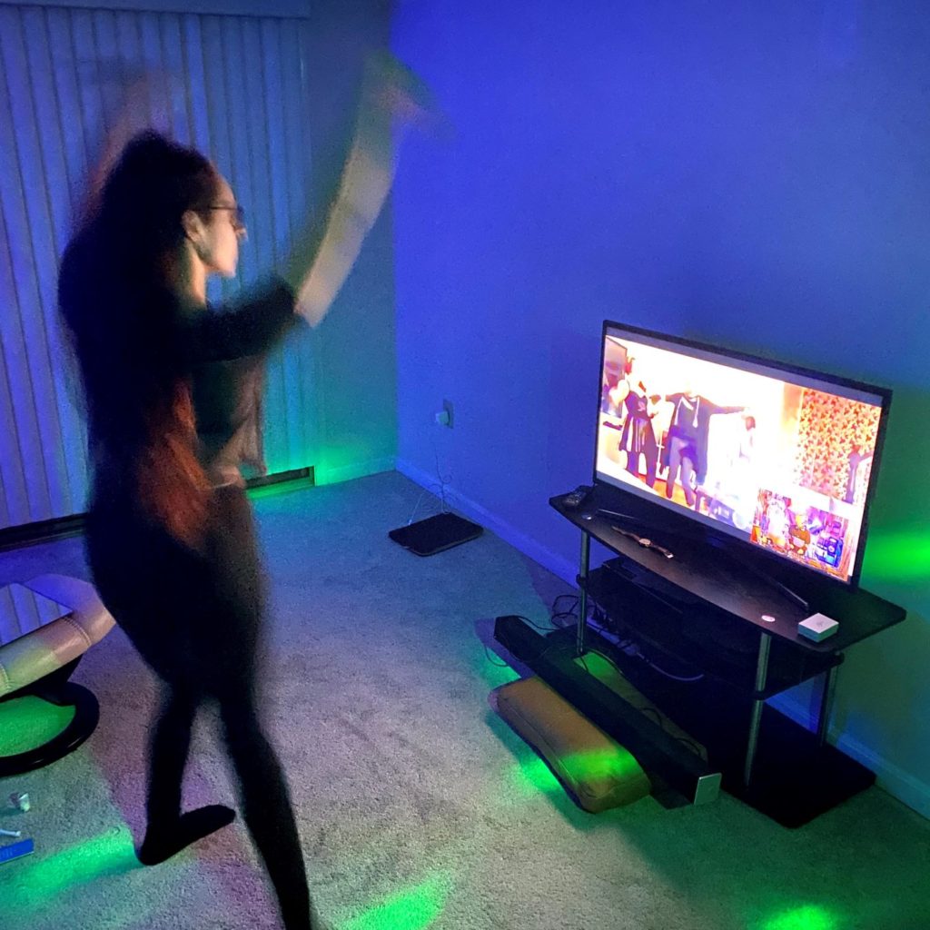 Julie dancing in front of the TV with colorful lights